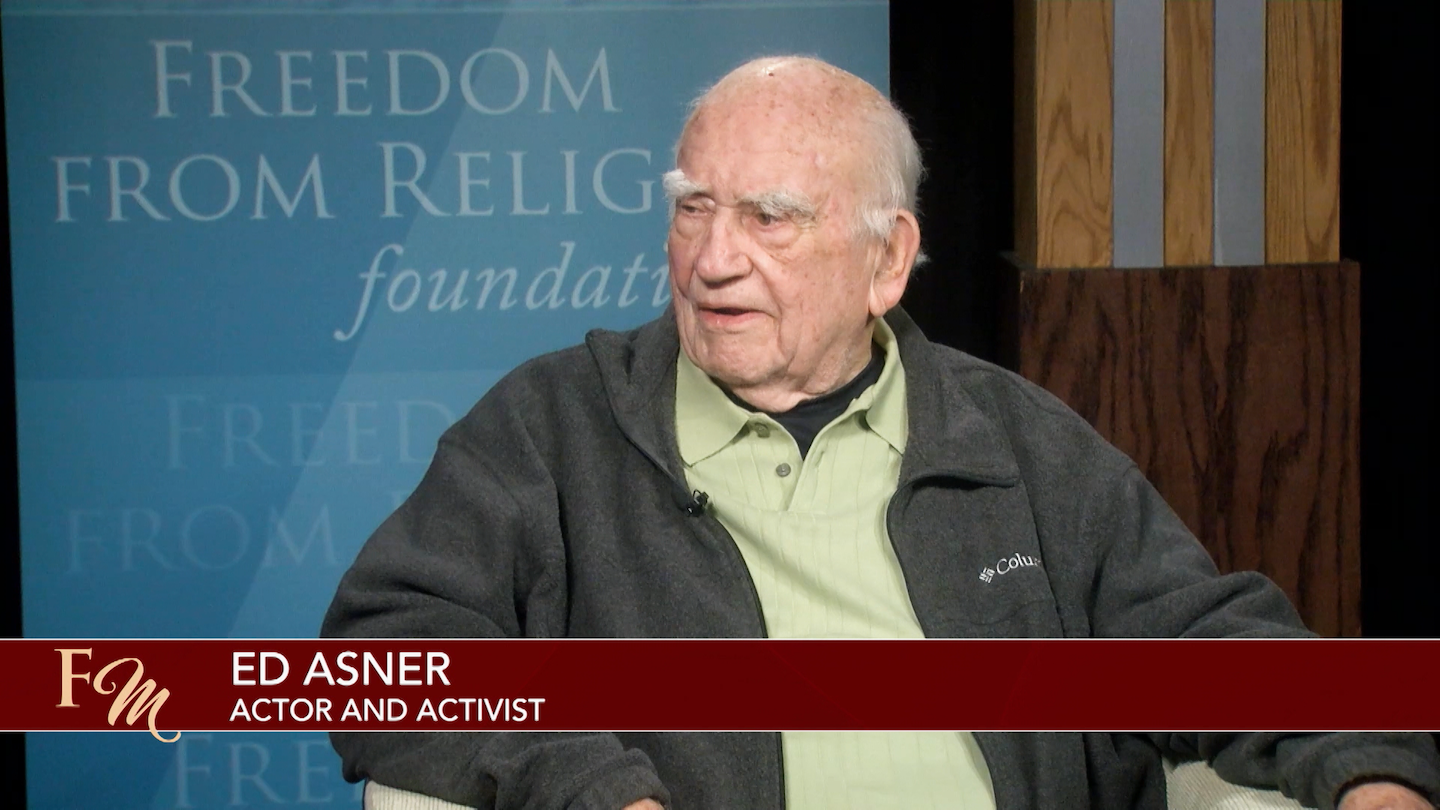 Ed Asner being interviewed on TV
