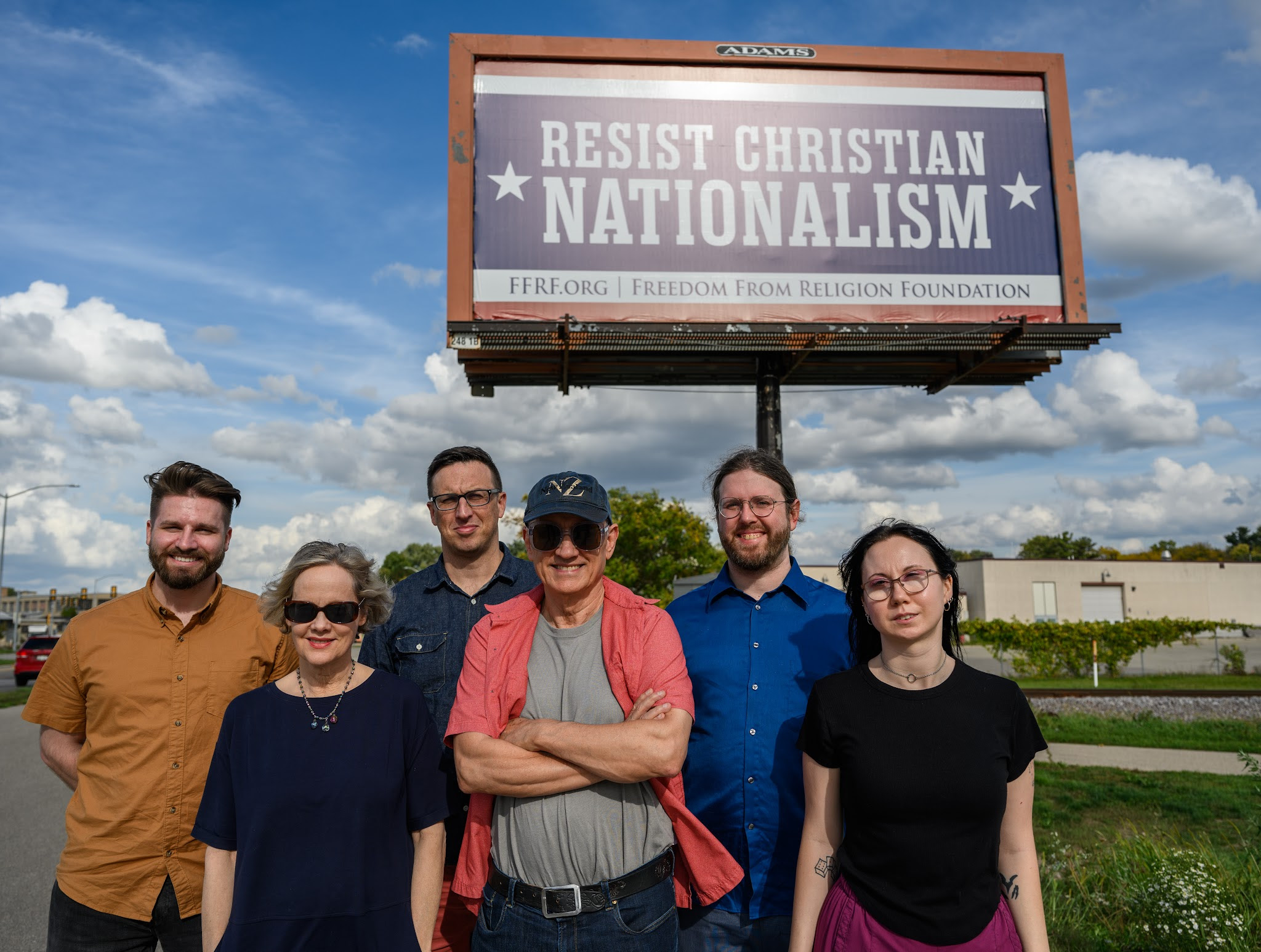 FFRF staff members standing in front of billboard that says "Resist Christian Nationalism"