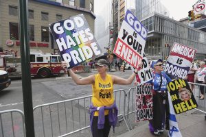 A westboro baptist church rally-goer holding up offensive signs