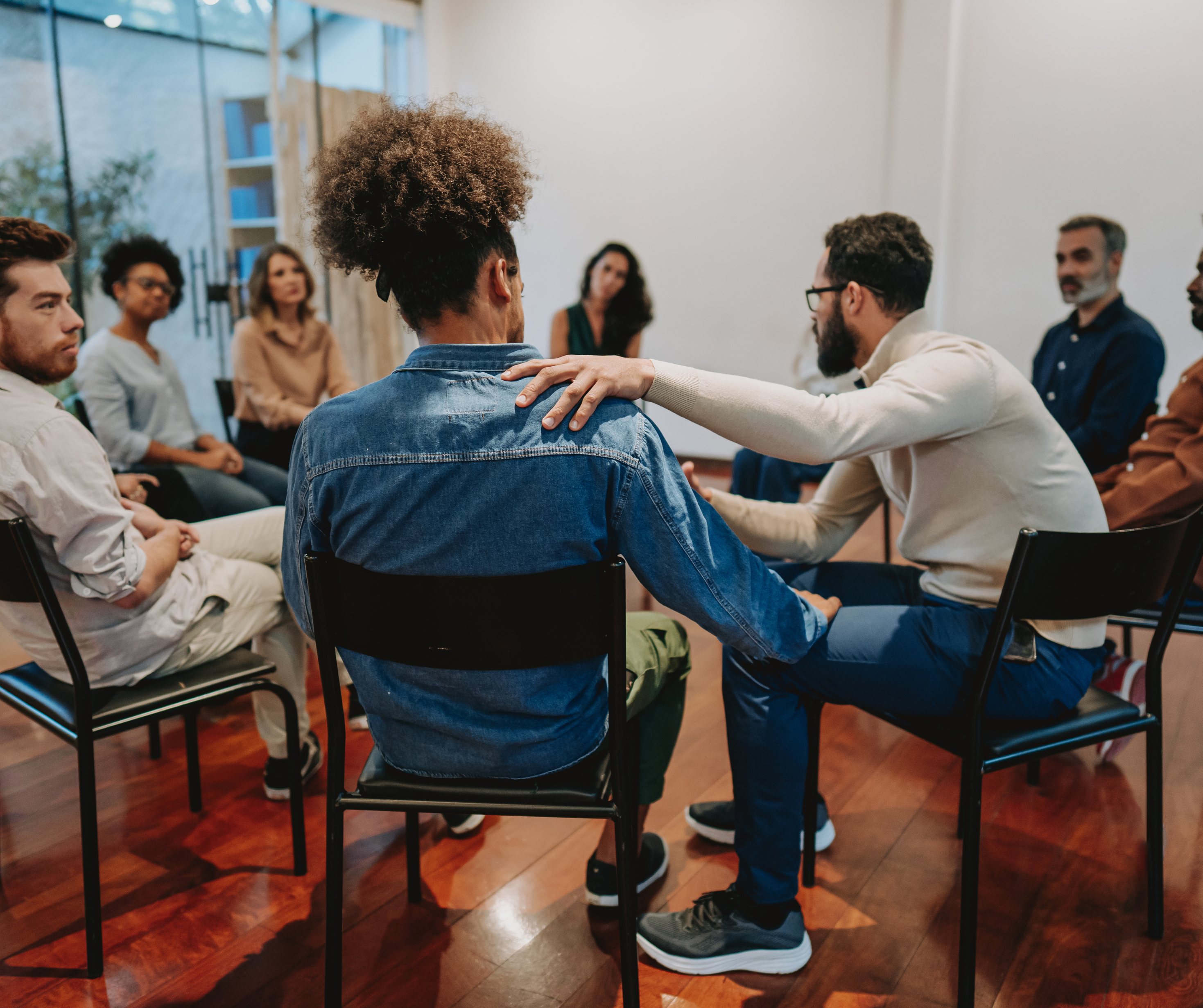 A group of people in a recovery meeting sitting in a circle
