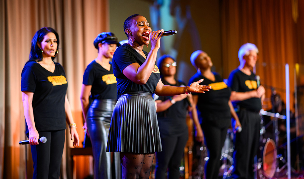 A soloist singing with a chorus behind her