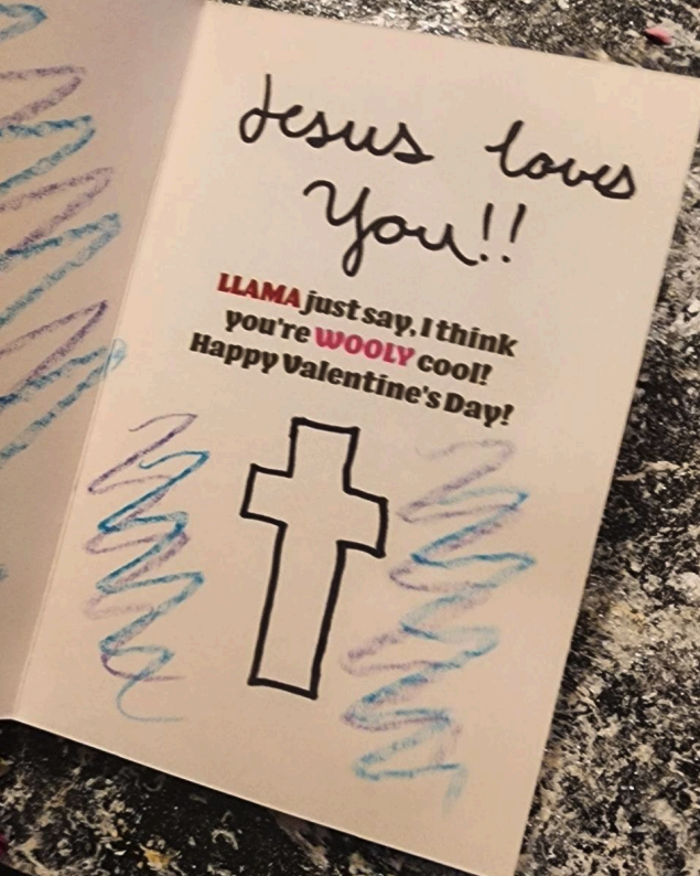 the inside of a homemade card that reads "Jesus loves you!! Llama just say, I think you're wooly cool! Happy Valentine's Day!" with a doodle of a Christian cross underneath